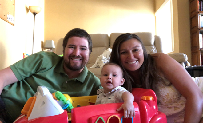 Cambrey smiling with her husband and son.