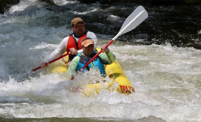 Caroline Mageau Starnes and a man white water rafting.
