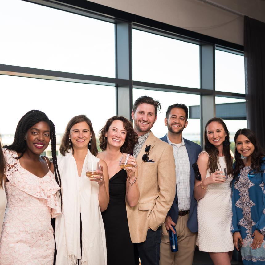 A group of 9 young adults smiling and looking at the camera. They are dressed in fancy clothing, attending one of the CF Foundation "Finest" events.