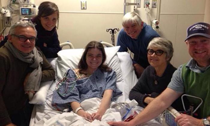 A family supporting a lung transplant patient who sits in a hospital bed