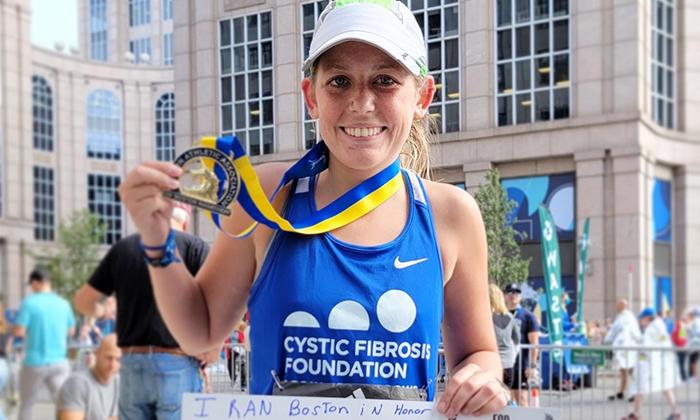 Katie O'Grady holding medals after running Boston Marathon