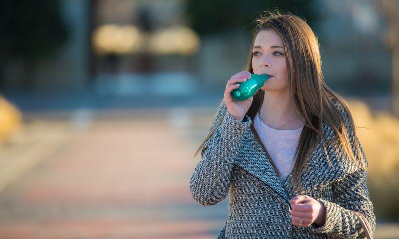 Jordan, an adult with CF, using a PEP device before huff coughing to clear mucus from her lungs.