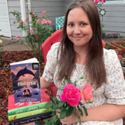 Cynthia Baldwin holding flowers and smiling with her published books