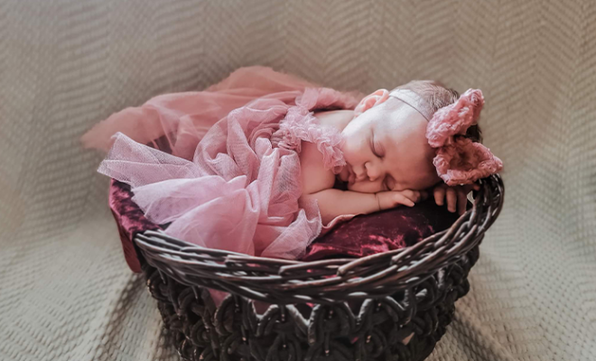 Newborn baby Eden laying in a basket.