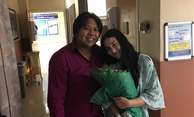 Morgan Nudel holding flowers in a hospital room